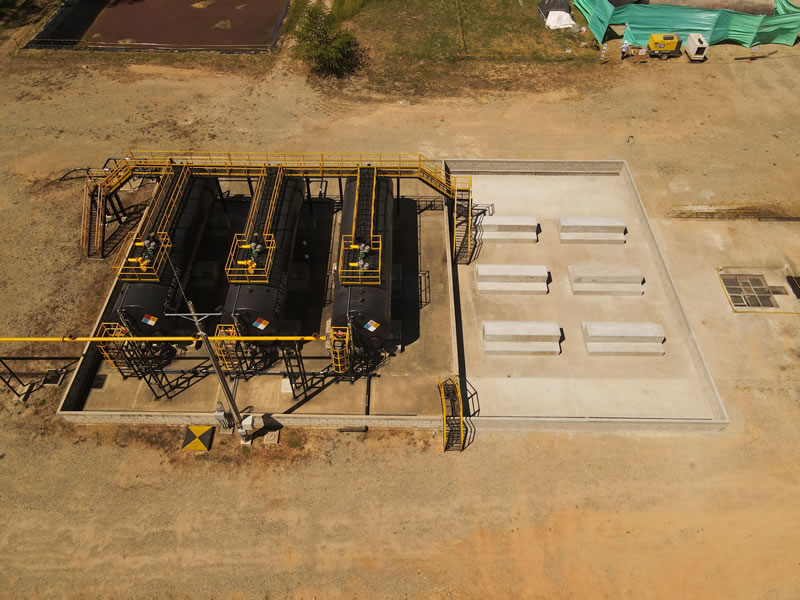 Vista aérea de un dique de contención en concreto con tanques y bases de concreto